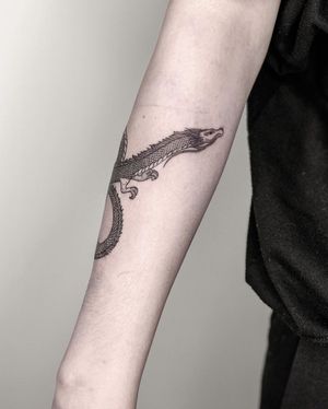 Experience the power of a blackwork dragon tattoo on your forearm, created by the talented artist Alisa Hotlib.