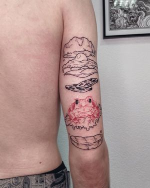 Unique upper arm tattoo by Anna featuring a frog, pizza, toad, bread, and hamburger in illustrative blackwork style.