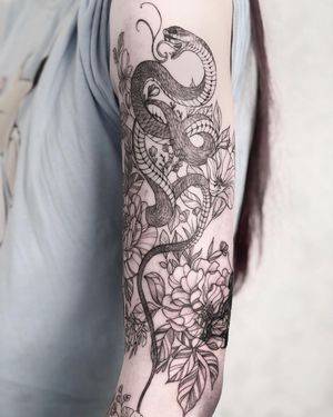 Elegant blackwork snake intertwining with a beautiful flower, expertly inked by Alisa Hotlib.