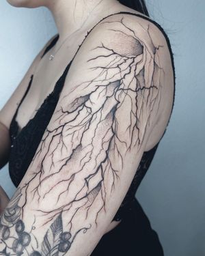 Get electrified with Anna's intricate blackwork design on your upper arm. A striking combination of lightning and patterns.