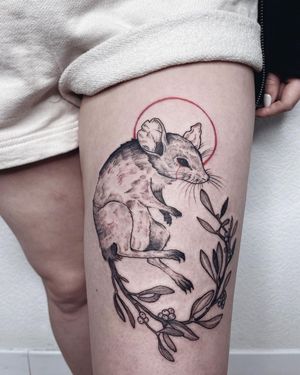 Illustrative design featuring a flower, rat, and tears on the upper leg by tattoo artist Anna.