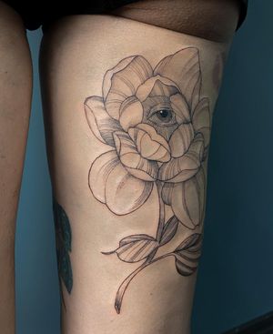 Unique blackwork tattoo of a flower and eye design on upper leg, by talented artist Alisa Hotlib. Stunning and intricate!