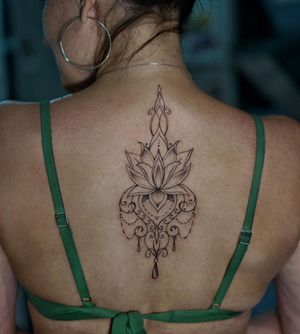 Beautiful blackwork design by Lim featuring intricate lotus flower and mandala patterns, perfect for upper back placement.