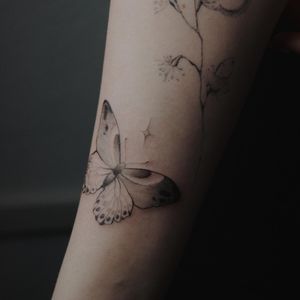 Unique blackwork butterfly design by Alisa, beautifully inked on the forearm for a striking and intricate look.