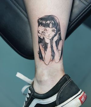 A striking blackwork tattoo on the ankle featuring an illustrative design of a woman entwined with a monster, expertly done by artist Lim.