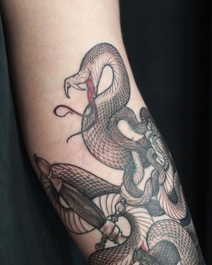 Illustrative forearm tattoo by Slava featuring a striking combination of snake and flower motifs.