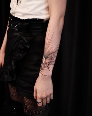 Check out this stunning blackwork and fine line tattoo on the forearm by artist Slava, featuring a beautiful geometric butterfly motif.
