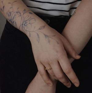Elegant blackwork forearm tattoo featuring a beautifully detailed illustrative flower design by talented artist Alisa.