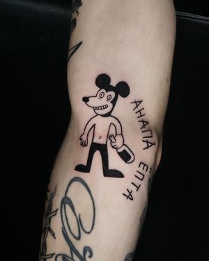 Unique blackwork design combining Mickey Mouse, bottle, and quote on arm by tattoo artist Lim. Perfect blend of lettering and illustrative style.