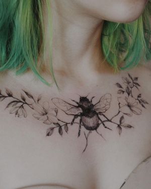 Get a fierce yet delicate blackwork chest tattoo of a flower and beetle by artist Alisa.