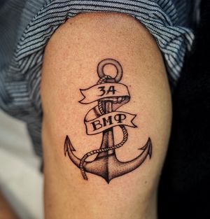 Get inked with Lim's blackwork illustrative design on your upper arm featuring an anchor, rope, lettering, and a meaningful year. Perfect for sailors and sea lovers.