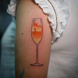 Raise a glass to Lim's impeccable neo-traditional style, featuring a stunning champagne glass motif on the upper arm.