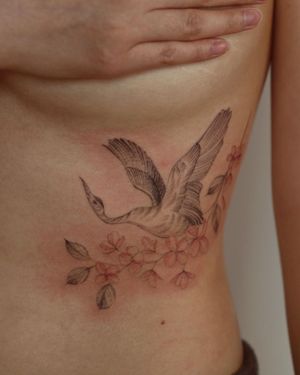 Intricate blackwork design by Alisa featuring a beautiful flower and elegant heron on the ribs.
