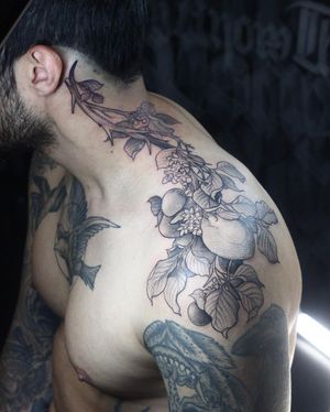 Beautiful blackwork tattoo featuring a delicate flower and fruit design, done by artist Slava.