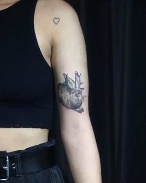 Get inked with a unique blackwork rabbit design with horns by Slava, perfect for the upper arm. Stand out with this illustrative piece!
