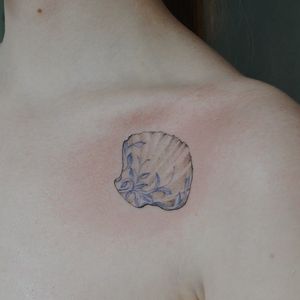Beautiful chest tattoo featuring a detailed illustrative design of a flower and shell, created by talented artist Alisa.