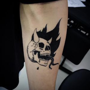 Bold blackwork and illustrative design featuring a menacing skull with devil horns, expertly done by Lim on the forearm.
