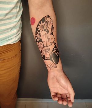 Baingio's stunning tattoo features a mix of flowers, hearts, patterns, and a woman, beautifully designed in bold blackwork style on the forearm.