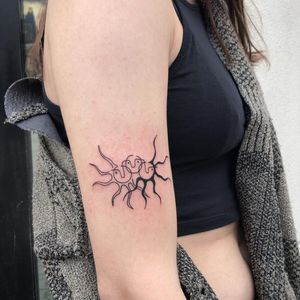 Get an intricately detailed blackwork illustration of the sun with a captivating pattern by Karyna on your upper arm.
