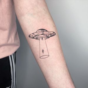 Elevate your style with a stunning blackwork and fine line illustrative tattoo featuring a unique pattern, spaceship, and alien design on your forearm.