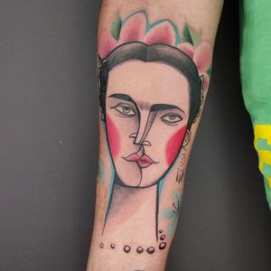 Express your artistic side with a vibrant floral portrait of Frida Kahlo on your forearm. By Baingio, this illustrative watercolor tattoo is a unique and stunning piece of art.