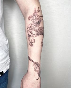 A stunning blackwork and fine line dragon tattoo on the forearm, created by the talented artist Kasia.
