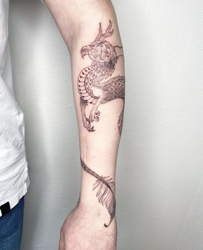 A stunning blackwork and fine line dragon tattoo on the forearm, created by the talented artist Kasia.