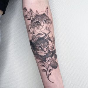 Experience a stunning fusion of fine line, blackwork, and realism by Kasia, featuring a geometric cat and delicate floral pattern.