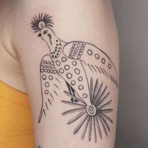 Get a stunning blackwork and illustrative tattoo on your upper arm by Mané. This intricate design features a bird, flower, and pattern.