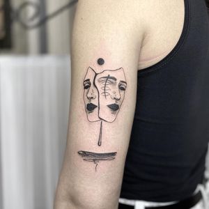 Elegant blackwork pattern featuring a woman and mask on upper arm by Mané.
