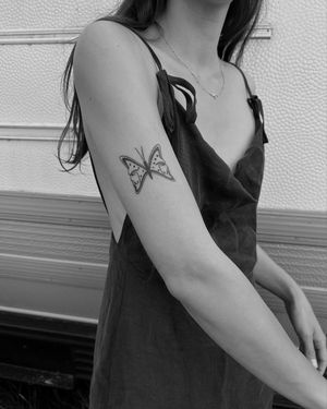 Experience the beauty of Karyna's blackwork butterfly design, perfectly placed on your upper arm.