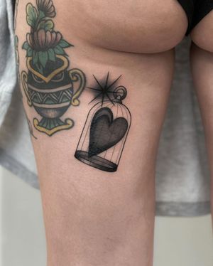Unique blackwork and fine line illustrative tattoo featuring a bird, heart, and cage, by Joanna on the upper leg.