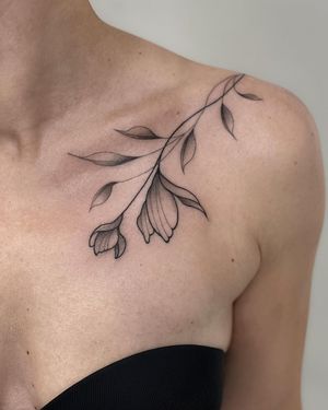 Blackwork flower tattoo on shoulder created by Joanna, featuring intricate linework and bold shading.