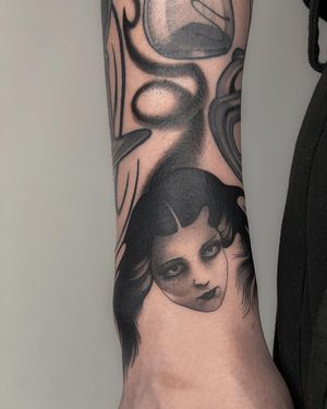 Get a striking blackwork tattoo of a woman on your sleeve by the talented artist Joanna. Perfect for those who love bold and detailed designs.