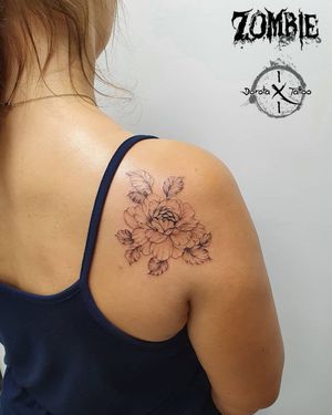 Elegant blackwork and fine line flower design on shoulder by Dorota, expert in illustrative tattoos.