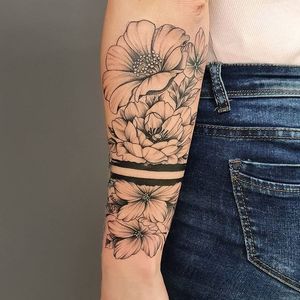 Get a stunning blackwork flower tattoo on your forearm by Dorota, with intricate illustrative details.
