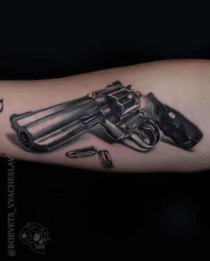 Bold blackwork design featuring a realistic gun and bullet, by the talented artist Slava.