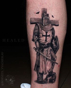 Intricate blackwork design featuring a warrior with a sword, shield, and cross, done by the talented artist Slava on the lower leg.