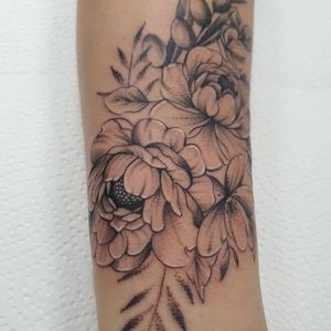 Elegant blackwork design with intricate ornamental details, featuring a beautiful flower motif on the arm by tattoo artist Dorota.