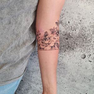 Beautiful illustrative blackwork tattoo of a peony flower on the forearm, done by artist Dorota.