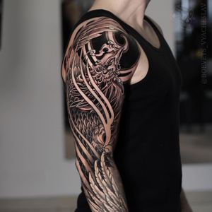 Experience the beauty of Japanese blackwork with this illustrative tattoo featuring a phoenix, feather, and wings. Expertly crafted by the talented artist Slava.