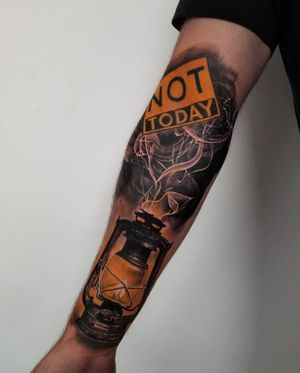 Unique blackwork forearm tattoo by Csaba Sipos, featuring a lantern, inspiring quote, and realistic smoke details.