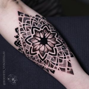 Get a stunning blackwork mandala with intricate patterns and dotwork details by the talented artist Slava.