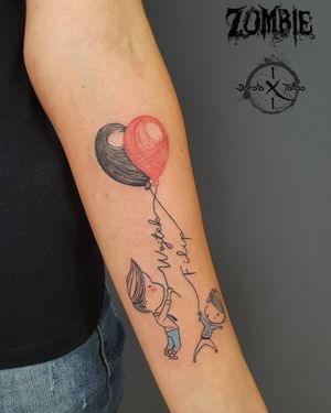 Fine line tattoo on forearm featuring a heart, quote, and child's name with illustrative elements like a balloon.