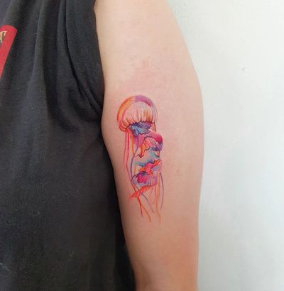 Adorn your upper arm with a stunning watercolor jellyfish tattoo by Dorota. Stand out with this unique and artistic design.