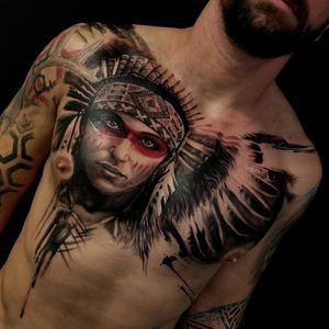 Discover the beauty of Csaba Sipos's blackwork style with this stunning chest tattoo featuring a realistic native girl and feather design.