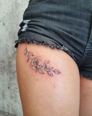 Beautiful blackwork and fine line flower tattoo on upper leg by Dorota, featuring intricate illustrative details.