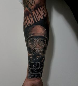 Blackwork, lettering, and realism merge in Csaba Sipos' sleeve tattoo featuring a soldier's helmet and powerful quote.
