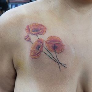 Orange California poppy flower on chest feminine tattoo
