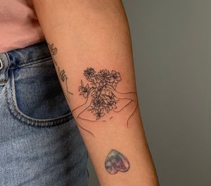 Minimal fine line tattoo ✨ client wanted something to represent her negative thoughts, so we picked some flowers that also have negative meanings — black dahlia, lilies, and narcissus (aka paper whites)